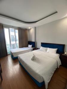um quarto de hotel com duas camas com um bicho de peluche em Mimi Housing em Hanói