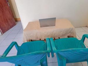 a table and a blue chair with a box on it at SPOT ON 93840 Guest House Amanda Syariah in Bandar Lampung