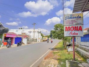 a sign for a momma salon on the side of a street at SPOT ON 93840 Guest House Amanda Syariah in Bandar Lampung