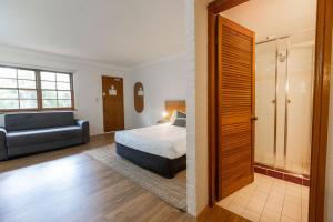 a bedroom with a bed and a couch in a room at Wisemans Retreat in Wisemans Ferry