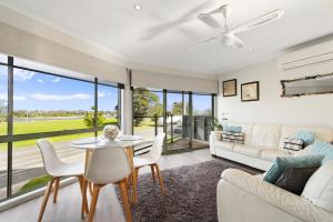 a living room with a table and chairs and a couch at Driftwood Townhouse - Waterfront-Central Location in Lakes Entrance