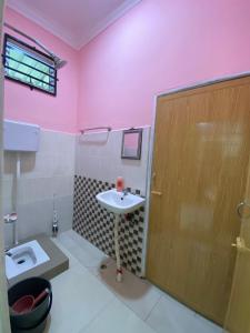 a pink bathroom with a toilet and a sink at Habib Homestay in Kuala Terengganu +14 photos