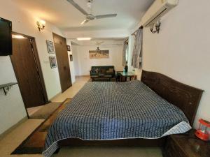 1 dormitorio con cama y sofá en Ivy's en Bhopal