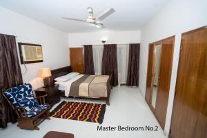 ein Schlafzimmer mit einem Bett, einem Stuhl und einem Fenster in der Unterkunft Swarloke Apartment at Gulshan 2,Dhaka in Dhaka