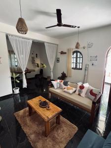 a living room with a couch and a table at Bayou Homestay and backwaters in Goa