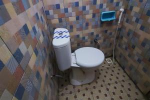a bathroom with a toilet in a tiled wall at Capital O 93842 Jowo Segoro Resort in Yogyakarta