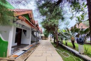 uma passagem em frente a um edifício com árvores em Capital O 93842 Jowo Segoro Resort em Yogyakarta
