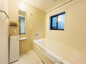a bathroom with a bath tub and a window at Meet Inari in Kyoto +24 photos