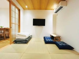 a living room with a flat screen tv on a wall at Meet Inari in Kyoto
