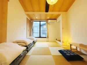 a room with two beds and a table and a window at Meet Inari in Kyoto