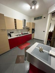a kitchen with red cabinets and a table in it at Casa Garruba Central Station in Bari