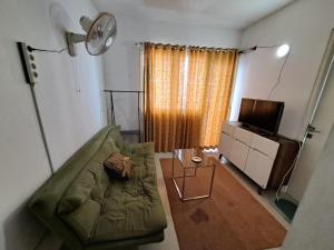 バンドンにあるOYO Life 93855 Apartement The Jarrdin By Apt Propertyのリビングルーム(緑のソファ、テレビ付)