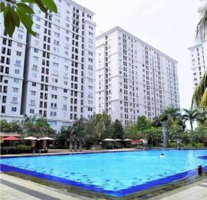 a large swimming pool in front of tall buildings at OYO 93857 Apartemen Kalibata City By Artomoro in Jakarta