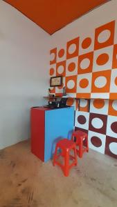 una habitación con una barra y dos taburetes en ella en SPOT ON 93852 Fermansio Homestay 2, en Medan
