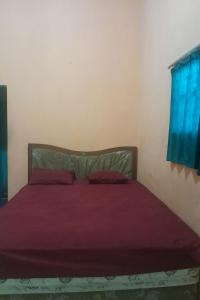 a bedroom with a bed with purple sheets and a window at SPOT ON 93852 Fermansio Homestay 2 in Medan