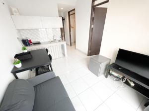 a living room with a couch and a television at OYO 93857 Apartemen Kalibata City By Artomoro in Jakarta