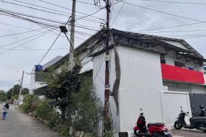 a white building with a red stripe on it at Hotel O Kost Reski 2 Near Tugu Perbatasan Takalar - Gowa in Rambia
