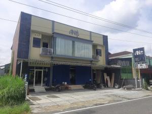 a blue and yellow building with motorcycles parked in front of it at OYO 93860 Wonosobo Bunkbed in Wonosobo
