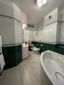 a bathroom with a tub and a toilet and a sink at Casa Garruba Central Station in Bari