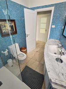 een blauw betegelde badkamer met een toilet en een wastafel bij Apartamento Drago in Santa Cruz de Tenerife