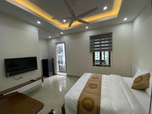 um quarto com uma cama e uma televisão de ecrã plano em Mimi Housing em Hanói