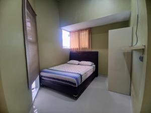 a small bedroom with a bed and a window at Cozy73 Ocean View Villa Uluwatu in Uluwatu