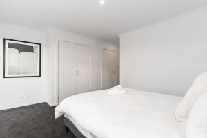 Un dormitorio blanco con una cama blanca y una ventana en Mellow Berwick Home, en Berwick