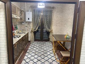 uma cozinha com um lavatório, uma mesa e uma porta em Квартира 3-ух Комнатная в центре города em Fergana
