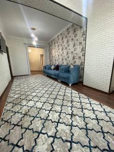uma sala de estar com um sofá azul e um tapete em Квартира 3-ух Комнатная в центре города em Fergana