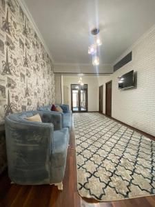 a living room with a blue couch and a wall at Квартира 3-ух Комнатная в центре города in Fergana