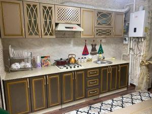 uma cozinha com um lavatório e um fogão forno superior em Квартира 3-ух Комнатная в центре города em Fergana