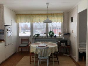 een keuken met een tafel met stoelen en een raam bij Villa Marlise in Hammarstrand