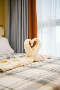 a pair of towels in the shape of a heart on a bed at BGC 2BR Uptown Parksuites with balcony and bathtub in Manila