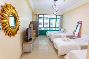 pokój hotelowy z 4 łóżkami i lustrem w obiekcie MC Budget Rooms for Girls Apartment Number 4202 w Dubaju