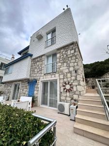 a stone house with a staircase in front of it at Tepe Hotel in Alaçatı