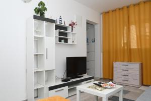 sala de estar con TV y mesa en Apartment Oscar en Mokošica