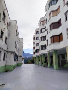 een lege parkeerplaats tussen twee hoge gebouwen bij El refugio de lastres in Lastres