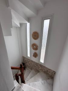a white room with two windows and a staircase at Tepe Hotel in Alaçatı +59 photos