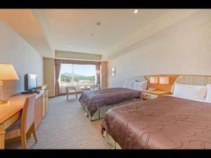 a hotel room with two beds and a desk at LiVEMAX RESORT Hakodate Greenpia Onuma in Mori
