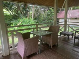 une terrasse couverte avec une table et des chaises. dans l'établissement Bungalow Sarraméa, à Sarraméa