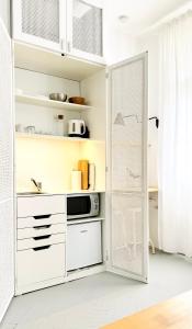 a kitchen with white cabinets and a door at Jardin Rooms in Split