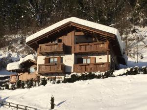 una baita di tronchi nella neve con neve di Casa Vacanze Villa Elena ad Alleghe