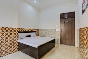 Camera con letto e porta in legno di OYO S.R Group Of Hotel a Kānpur