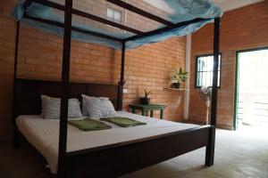 a bedroom with a canopy bed in a brick wall at PASSIONFRUIT HOMESTAY in Matara