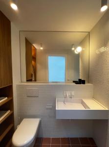 uma casa de banho com um lavatório, um espelho e um WC. em Bergerie casitas suite em Canet-en-Roussillon