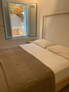 a bedroom with a large bed with a window at Mykonian 4 Bd Ocean Dream House in Agios Sostis in Agios Sostis Mykonos