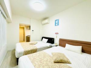 ein Hotelzimmer mit 2 Betten und einem Fenster in der Unterkunft Legatio Hakataekihigashi Hotel in Fukuoka