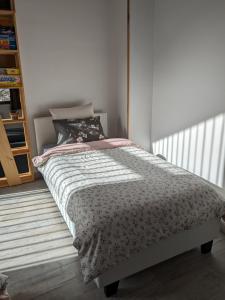 Un dormitorio con una cama con una manta. en Gîte Reflets de Montagnes, en Tarascon-sur-Ariège