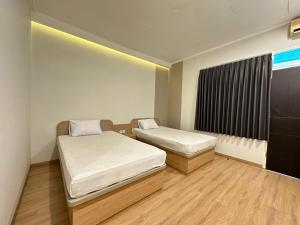 mały pokój z 2 łóżkami i oknem w obiekcie Hotel Plampitan w mieście Semarang