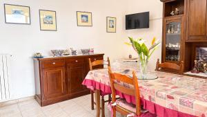 una sala da pranzo con tavolo e vaso di Villa La Magnolia a Ischia